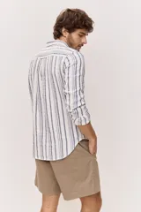 Camisa de manga larga de lino con diseño a rayas en tonos celestes y blancos, cuello camisero clásico y cierre frontal de botones.