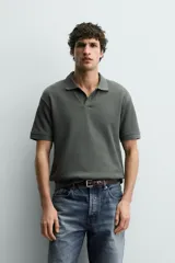 Polo regular fit color verde militar con textura acanalada vertical, cuello solapa con abertura frontal, manga corta y acabados en rib.