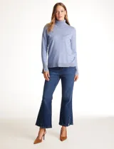 Polera de tejido fino, color rosado, con cuello alto, manga larga y detalle de tajo en los puños.