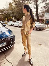 Pantalón de lino metalizado color dorado, de corte recto, con bolsillos laterales y traseros, y elástico en la cintura.