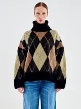 Buzo de punto con diseño de rombos en colores negro, marrón y verde, de calce amplio y cuello tortuga. Confeccionado en una mezcla de lana y alpaca con textura suave y vellosa.