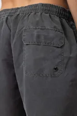 Short de baño de corte relajado en color gris azulado con efecto lavado. Cuenta con cintura elastizada con cordón ajustable, bolsillos laterales y una pequeña etiqueta decorativa en el ruedo.