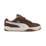 Championes Puma Park Lifestyle Easy de estilo urbano, confeccionados en gamuza color marrón con la icónica franja lateral de la marca en color blanco. Presentan una suela de goma en tono crema y base marrón, con interior acolchado blanco.
