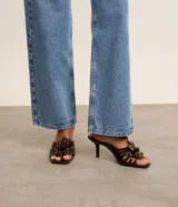 Sandalia mule color marrón con punta cuadrada, tira con flor y aplicación de strass, y tacón fino alto.