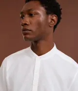 Camisa de manga corta confeccionada en mezcla de lino y algodón, con cuello tipo padre y cierre frontal parcial con botones.