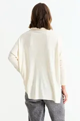 Cardigan de punto color crema, con cuello camisero, cierre frontal de botones y bolsillo frontal en el pecho.