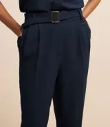 Pantalón zanahoria de mujer confeccionado en tela airflow color azul marino, con trabillas en la cintura, cinturón con hebilla, pliegues y elástico en la espalda.