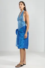 Traje de baño enterizo con estampado animal print en tonos de azul, con escote halter y espalda descubierta.