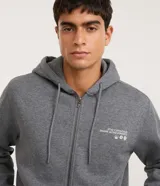 Campera masculina de moletón gris grafito con capucha, cierre frontal de cremallera y cordones ajustables. Presenta estampa localizada en el pecho con texto y gráficos, bolsillos amplios y puños y cintura ajustados.