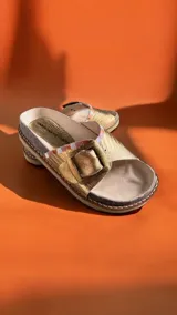 Sandalias de cuero dorado marca Carolina De Cunto, con tira ancha ajustable mediante hebilla metálica grande personalizada y detalles pintados a mano. Suela de goma eva ligera.
