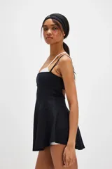 Vestido deportivo corto de color negro, con diseño fluido, tirantes finos y escote recto, ideal para tenis o actividades al aire libre.