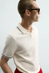 Polo de punto tejido en algodón, de corte regular fit. Presenta cuello solapa con cierre frontal de botones y manga corta, con acabados en rib y detalles de bandas a contraste en cuello y puños.
