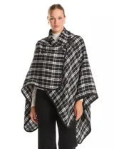 Ruana tejida con diseño de cuadros en blanco y negro, con borde ribeteado y cierre frontal tipo trenca con detalle de cuero sintético.