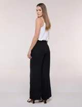 Pantalón de vestir de tiro alto, color beige, con corte wide leg y pinzas frontales.