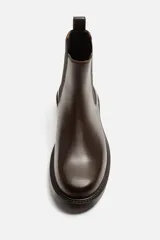 Bota tipo Chelsea de piel color marrón oscuro, con paneles elásticos laterales, tirador trasero y suela de goma con ligero tacón.