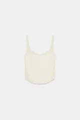 Top corsetero de color marfil confeccionado en tejido elástico, con escote redondo, tirantes anchos y costuras marcadas que estructuran la prenda.