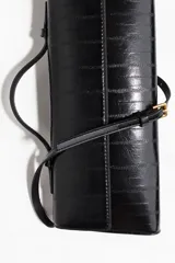 Cartera rectangular de diseño estructurado con acabado brillante y textura de piel de animal. Cuenta con una solapa frontal con cierre magnético, un asa superior fija y una correa larga ajustable y extraíble.