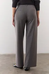 Pantalón marrón de corte recto y pierna ancha, con cintura alta, bolsillos laterales y cierre.