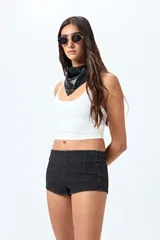 Microshort de tiro bajo color negro, con cierre metálico en la espalda, de calce ajustado y largo mini.