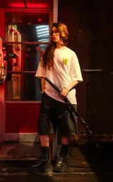 Remera blanca de corte holgado con un pequeño estampado amarillo en el pecho, inspirado en la película Kill Bill.