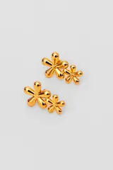 Par de caravanas doradas con forma de flores de cinco pétalos. Cada caravana tiene dos flores de diferente tamaño.