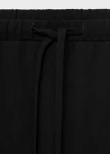 Pantalón negro de tiro medio con cintura elástica y lazo ajustable, de diseño recto.