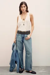 Jeans de corte barrel color celeste, confeccionados en 100% algodón, con diseño de perneras curvas y costuras decorativas en las rodillas.
