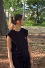 Musculosa negra de algodón, corte oversize, con un pequeño logo estampado en el pecho y un diseño gráfico grande en la espalda.