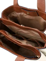 Cartera tipo tote de cuero color crema, con asas de hombro y detalles en marrón tostado. Incluye un llavero colgante de flecos de cuero y herrajes metálicos dorados.