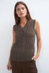 Chaleco de lana color crudo, tejido con escote en V y diseño con diferentes puntos combinados en el frente.