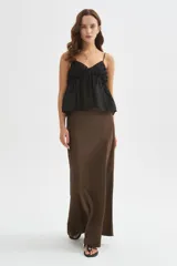 Musculosa de lyocell color negro, de diseño holgado, con breteles finos regulables, escote en V y detalles de volados.