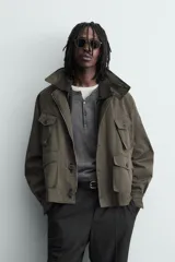Cazadora relaxed fit de tejido con mezcla de algodón en color verde militar. Cuenta con cuello subido, manga larga con puño ajustable, múltiples bolsillos frontales de plastrón con solapa y cierre frontal con botones.