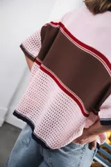 Remera de punto con diseño retro de bloques de color en marrón, crema y celeste. Presenta cierre frontal, cuello redondo, mangas cortas y tejido calado en la parte inferior. Incluye detalle de logo en relieve en el frente.