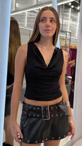 Top negro sin mangas, con escote drapeado y textura brillante sutil con trama geométrica.