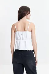Top blanco con breteles finos, escote recto y corte peplum con frunces en la cintura.