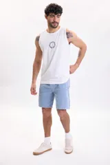 Bermuda de jean azul claro con lavado suave, bolsillos delanteros y traseros, y corte clásico de denim.
