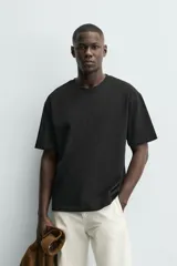 Camiseta de corte relajado confeccionada en algodón con textura irregular, cuello redondo y manga corta.