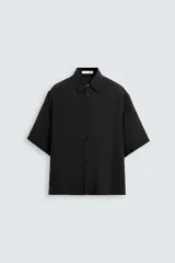 Camisa de corte relajado confeccionada en tejido fluido con mezcla de modal, cuello solapa, manga corta y cierre frontal con botones.