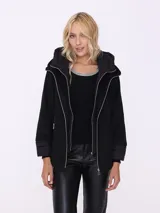 Saco negro con capucha y diseño matelassé.