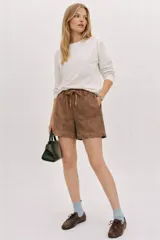 Short de tiro medio con cintura elastizada, confeccionado en mezcla de lino y algodón. Presenta un estampado marmolado artesanal en tonos marrones y beige, con detalle de entredos teñido a tono.