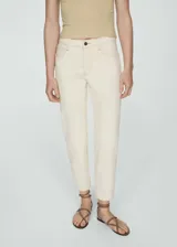 Jeans estilo mom-fit de tiro alto color beige, confeccionados en tejido elástico de algodón, con diseño de cinco bolsillos, trabillas y cierre frontal de cremallera y botón.