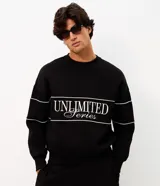 Buzo negro de cuello redondo, manga larga y calce boxy, confeccionado en mezcla de algodón y poliéster. Presenta recortes horizontales con vivos blancos en el pecho y las mangas, además de un diseño bordado con la inscripción "Unlimited Series".