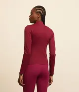 Campera deportiva de corte ajustado, confeccionada en tejido seamless de poliamida y elastano. Presenta cuello alto, cierre frontal con cremallera y textura acanalada.