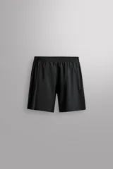 Pantalones deportivos cortos de tejido técnico ligero y elástico, con cintura elástica ajustable, bolsillos frontales y aberturas laterales en el bajo.