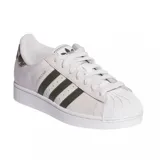 Championes Adidas Superstar de diseño clásico, color blanco con las icónicas tres tiras laterales en tono gris oscuro. Presenta detalle de estampado animal print en el talón y puntera de goma reforzada.
