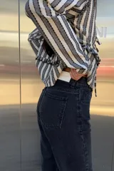 Pantalón de jean recto color negro con detalle desflecado en los tobillos.