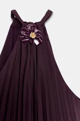 Vestido midi plisado color bordó, con cuello halter, broche de flor en el delantero y anudado en la espalda. Cuenta con forro interior.