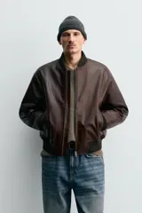 Cazadora bomber de corte regular confeccionada en piel encerada color marrón oscuro. Presenta cuello, puños y bajo en tejido rib elástico, cierre frontal con cremallera y bolsillos laterales con cierre.