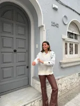 Buzo color blanco con cuello en V, mangas largas y estampado de lunares negros.