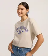 Remera de algodón color beige claro, manga corta y escote redondo, con estampado frontal en azul que dice "Copenhagen 1996" en tipografía universitaria rodeado de estrellas.